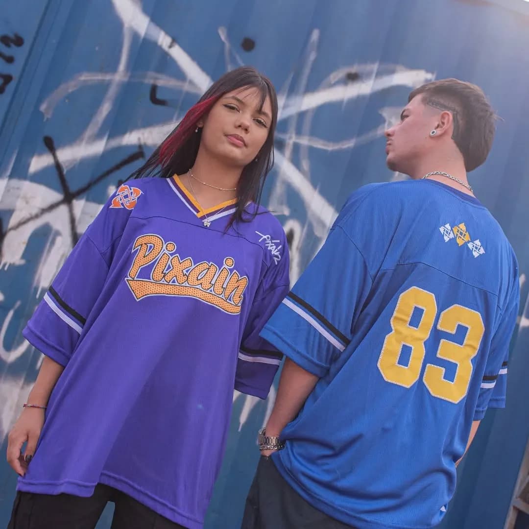 Casal de camisa de futebol americano Pixain em frente ao contêiner azul